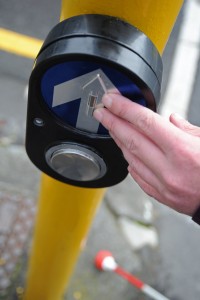 Person about to push button at pedestrian crossing