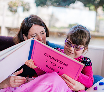 Laura and mum reading a tactile book together