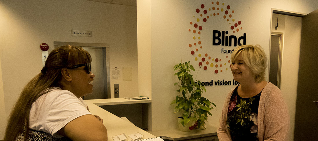 A woman chats to the receptionist at a Blind Foundation office.