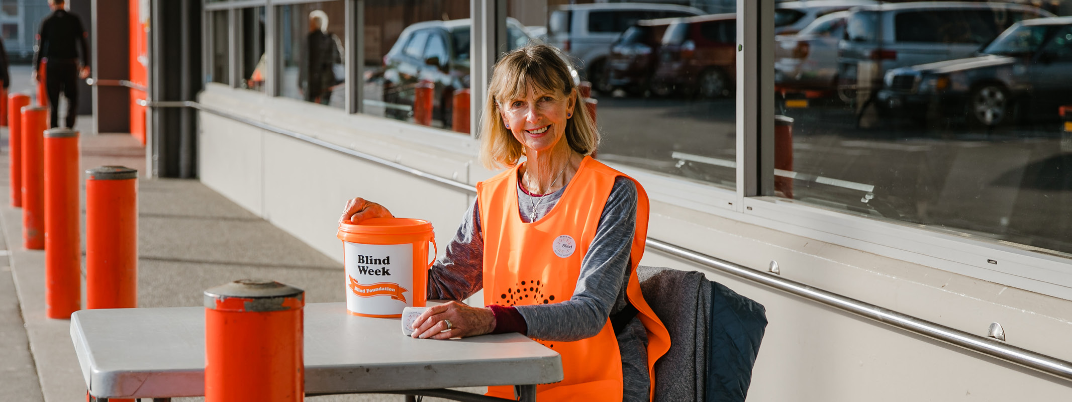 Sue holding a bucket and sitting on a chair
